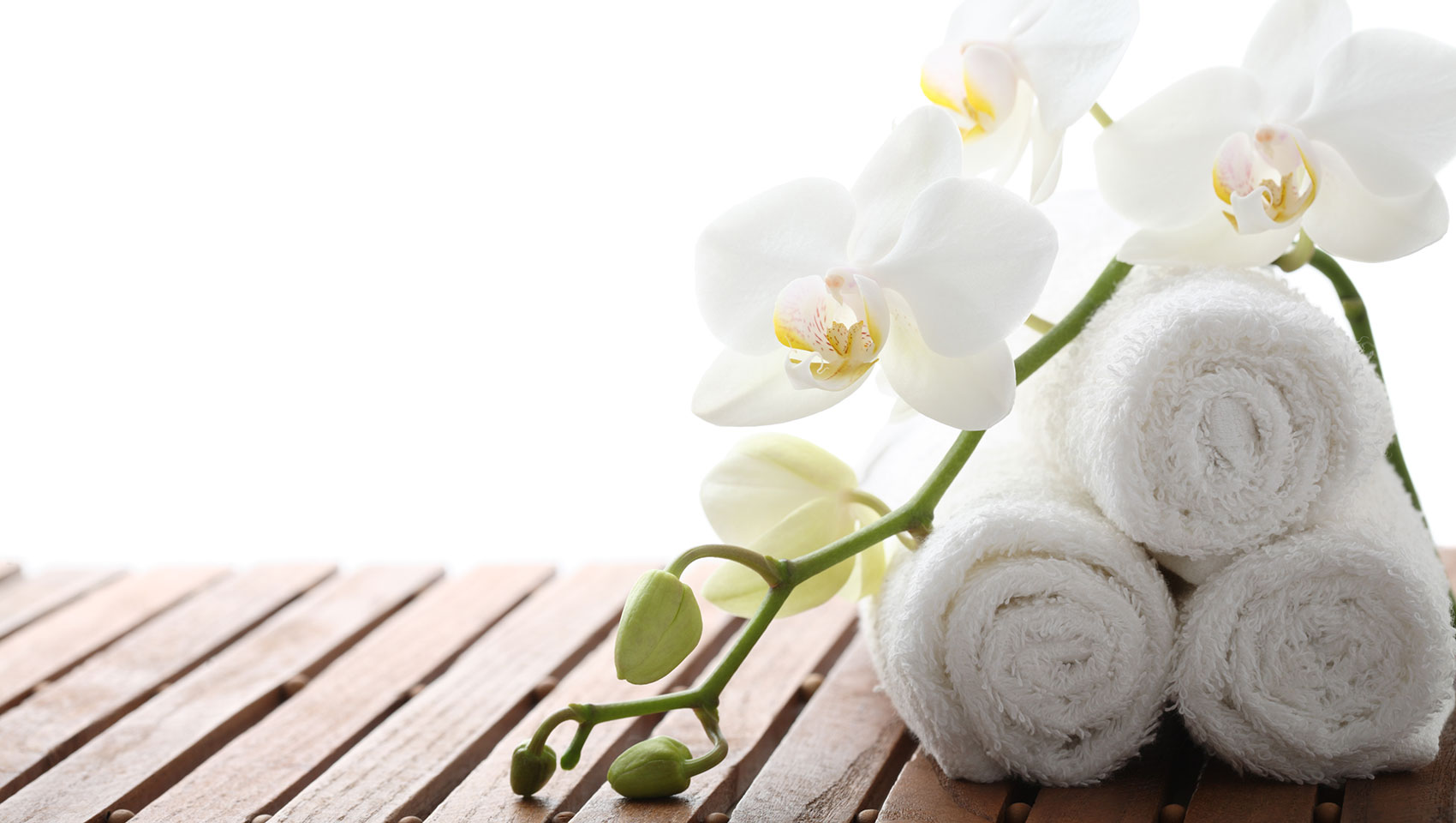 towels and orchids on a wood bench