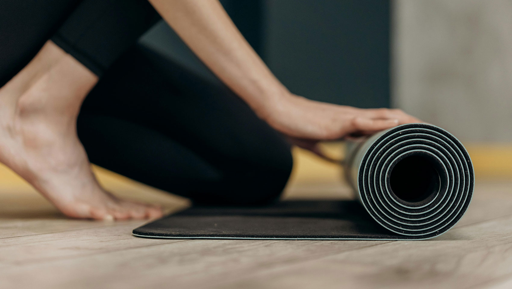 woman rolling up yoga mat