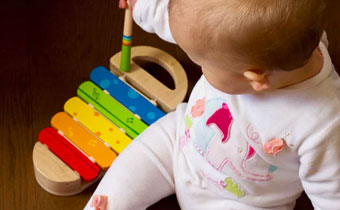 baby playing with a xylophone